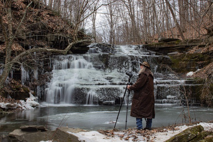 Photographer Standing Near The Waterfall